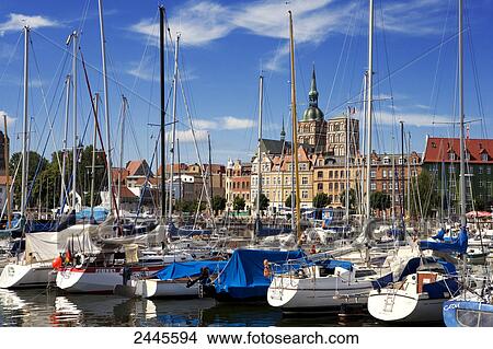 Picture - Fishing boats at harbor which church in background, St. Nikolai Russian Church, Stralsund, Mecklenburg-West Pomerania, Germany . Fotosearch