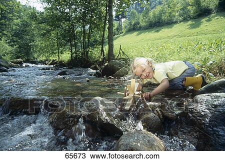 Stock Image - Girl playing at creek . Fotosearch