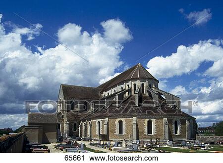 Stock Image - Graves and church under cloudy sky, Burgundy, France . Fotosearch