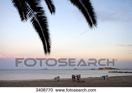 Stock Image - Group of people on the beach, Ses Figueretes, Ibiza, Spain, elevated view . Fotosearch