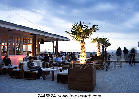 Group of tourists sitting at resort on beach, Warnow, Rostock, Mecklenburg-Vorpommern, Germany View Large Photo Image Picture - Group of tourists sitting at resort on beach, Warnow, Rostock, Mecklenburg-Vorpommern, Germany . Fotosearch