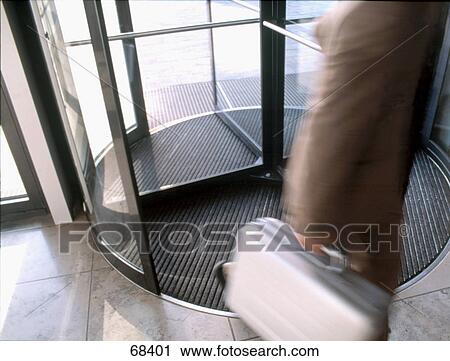 High angle view of businessman walking through revolving door View Large Photo Image Stock Image - High angle view of businessman walking through revolving door . Fotosearch