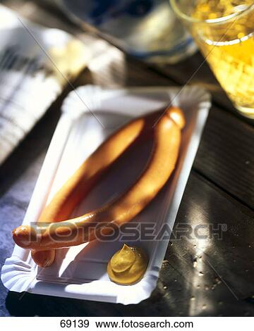 Stock Photo - High angle view of sausages and mustard sauce on plate . Fotosearch