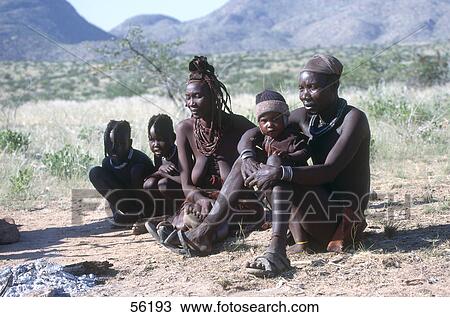 Stock Image - Himba family sitting in desert, Kaokoveld, Namibia . Fotosearch