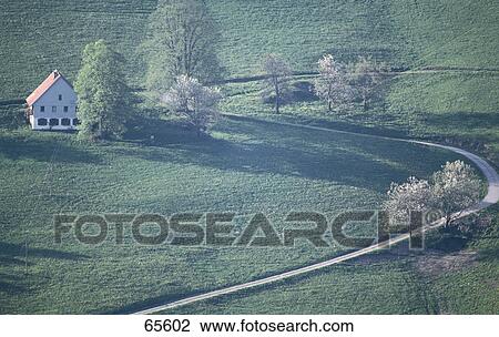 Stock Image - House and trees along a winding road, Baden-Wurttemberg, Germany . Fotosearch