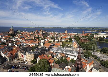 Stock Photography - Houses in town with church in background, St. Nikolai Russian Church, Stralsund, Rugen, Mecklenburg-West Pomerania, Germany . Fotosearch