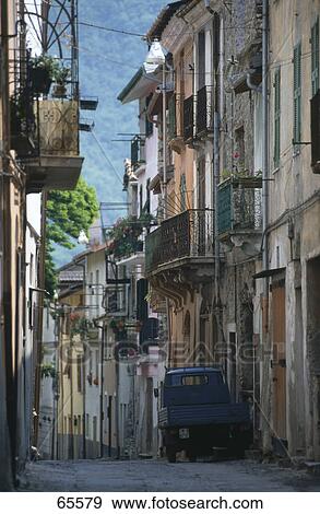 Stock Photo - Houses on both side of narrow alley, Tuscany, Italy . Fotosearch