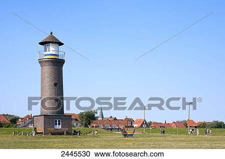 Lighthouse with buildings in background, Juist, Lower Saxony, Germany View Large Photo Image Stock Image - Lighthouse with buildings in background, Juist, Lower Saxony, Germany . Fotosearch