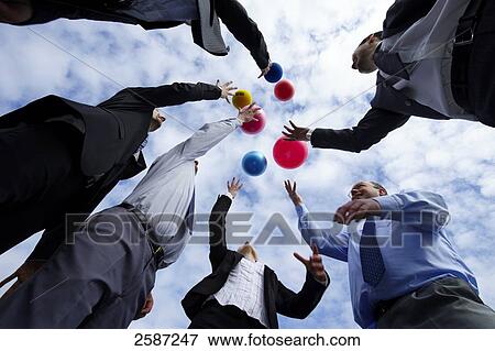 Low angle view of businesspeople throwing balls View Large Photo Image Stock Photo - Low angle view of businesspeople throwing balls . Fotosearch