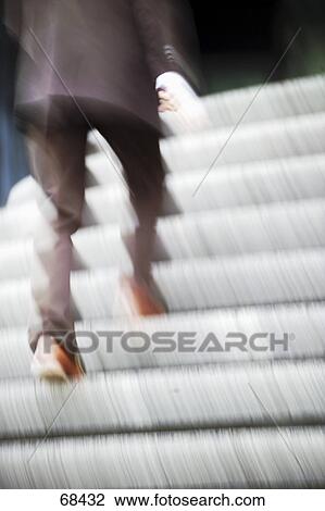 Stock Image - Low section view of businessmen walking upstairs . Fotosearch