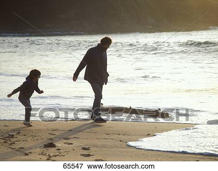 Man and his daughter walking on beach View Large Photo Image Stock Photo - Man and his daughter walking on beach . Fotosearch