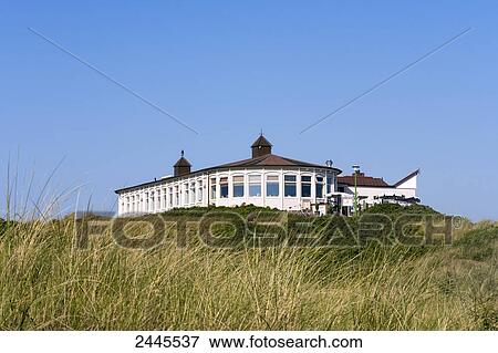 Stock Photo - Marram grass in field with building in background, Strandhalle, Langeoog, Lower Saxony, Germany . Fotosearch