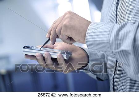 Mid section view of businessperson using PDA View Large Photo Image Stock Image - Mid section view of businessperson using PDA . Fotosearch