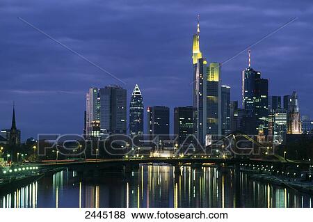 Stock Photo - Office buildings lit up at dusk, Frankfurt, Hesse, Germany . Fotosearch