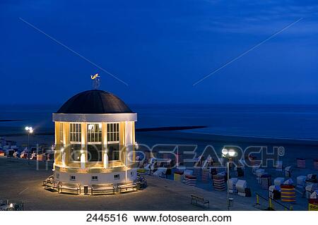 Stock Photograph - Pavilion and hooded beach chairs on beach at night, Borkum, Lower Saxony, Germany . Fotosearch