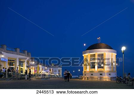 Stock Image - Pavilion at tourist resort lit up at night, Borkum, Lower Saxony, Germany . Fotosearch