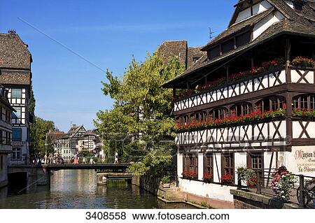 Stock Photo - Pedestrians on a bridge next to the restaurant Maison des Tanneurs, Strasbourg, France . Fotosearch