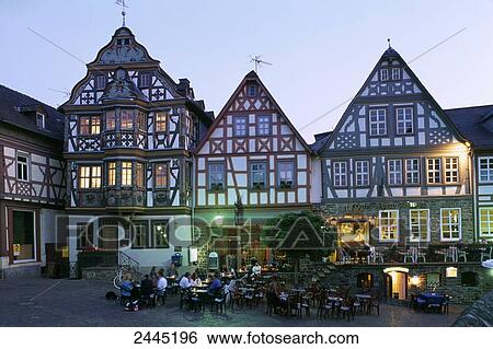 Stock Photograph - People in sidewalk cafe at dusk, Idstein, Darmstadt, Hesse, Germany . Fotosearch