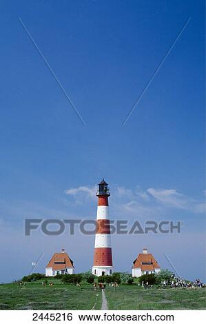 Stock Photograph - People on hill near lighthouse, Westerhever, Eiderstedt, Schleswig-Holstein, Germany . Fotosearch