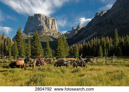 People riding horses with mountain in background, Wind River Range, Wyoming, USA View Large Photo Image Stock Image - People riding horses with mountain in background, Wind River Range, Wyoming, USA . Fotosearch
