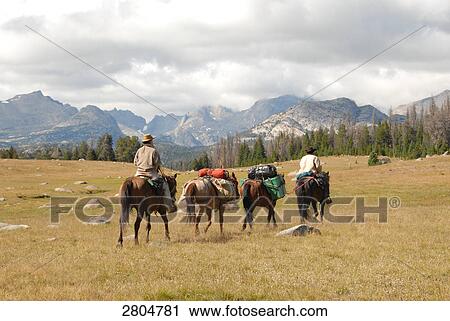 People riding horses with mountain range in background, Wind River Range, Fish Creek Park, Wyoming, USA View Large Photo Image Stock Image - People riding horses with mountain range in background, Wind River Range, Fish Creek Park, Wyoming, USA . Fotosearch