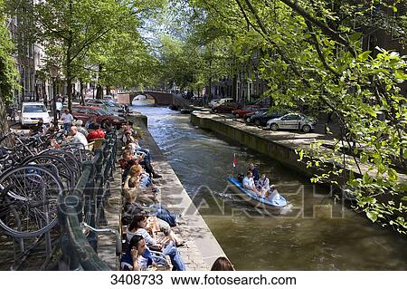 People sitting on the waterfront of Leliegrachtgracht, Amsterdam, Netherlands, elevated view View Large Photo Image Stock Image - People sitting on the waterfront of Leliegrachtgracht, Amsterdam, Netherlands, elevated view . Fotosearch