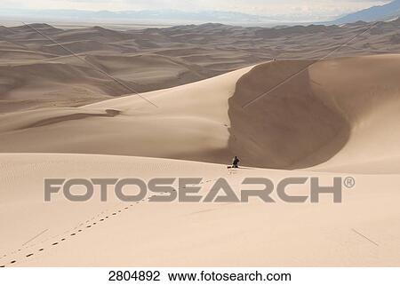 Person in sand dune, Great Sand Dunes National Park, Colorado, USA View Large Photo Image Stock Image - Person in sand dune, Great Sand Dunes National Park, Colorado, USA . Fotosearch