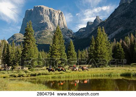 Picture - Person riding horse with mountain in background, Wind River Range, Wyoming, USA . Fotosearch