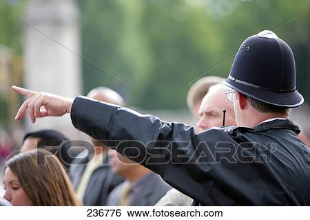 Policeman giving direction to tourists, London, England View Large Photo Image Stock Photograph - Policeman giving direction to tourists, London, England . Fotosearch