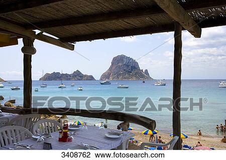 Stock Image - Restaurant patio, view of the rocky island Es Vedra, Ibiza, Spain . Fotosearch