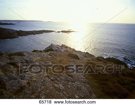 Rock formations at coast during dusk, Finister, Brittany, France View Large Photo Image Stock Photo - Rock formations at coast during dusk, Finister, Brittany, France . Fotosearch