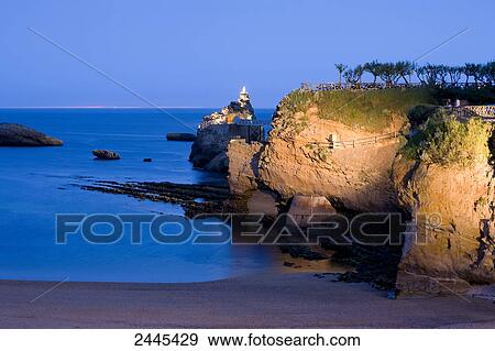 Stock Photo - Rocky coast at night with light house in background, Port Vieux, Biarritz, Pyrenees-Atlantiques, Aquitaine, France . Fotosearch