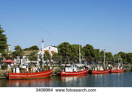 Row of fishing boats on the waterfront of Warnemuende, Rostock, Germany View Large Photo Image Picture - Row of fishing boats on the waterfront of Warnemuende, Rostock, Germany . Fotosearch
