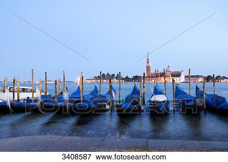Row of moored gondolas, San Giorgio Maggiore in the background, Venice, Italy View Large Photo Image Stock Photo - Row of moored gondolas, San Giorgio Maggiore in the background, Venice, Italy . Fotosearch