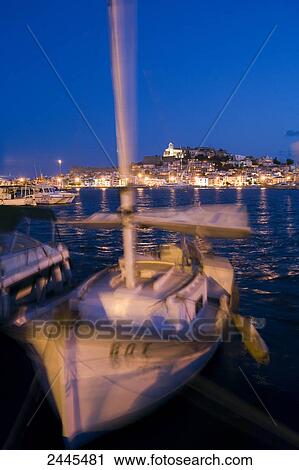 Stock Image - Sailboat at marina with town in background, Dalt Vila, Ibiza, Balearic Islands, Spain . Fotosearch
