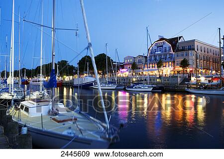 Sailboats in river with buildings in background, Rostock, Warnemunde, Mecklenburg-West Pomerania, Berlin, Germany View Large Photo Image Stock Photo - Sailboats in river with buildings in background, Rostock, Warnemunde, Mecklenburg-West Pomerania, Berlin, Germany . Fotosearch