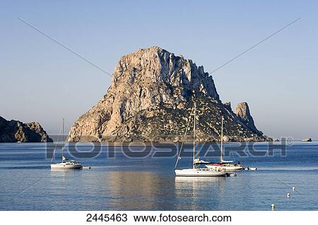 Sailboats in sea with rock formation in background, Es Vedra, Cala d'Hort, Ibiza, Balearic Islands, Spain View Large Photo Image Stock Image - Sailboats in sea with rock formation in background, Es Vedra, Cala d'Hort, Ibiza, Balearic Islands, Spain . Fotosearch