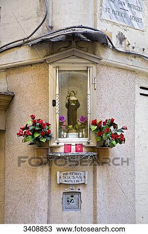 Stock Image - Sculpture on a house facade, Valletta, Malta, low angle view . Fotosearch