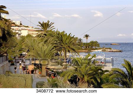 Stock Image - Seaside promenade and restaurant in Ses Figueretes, Ibiza, Spain, elevated view . Fotosearch