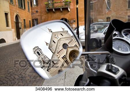 Stock Photograph - Side view mirror of a motorbike reflecting the Cathedral of Verona, Italy . Fotosearch