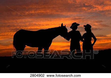 Silhouette of couple standing with horse View Large Photo Image Stock Image - Silhouette of couple standing with horse . Fotosearch