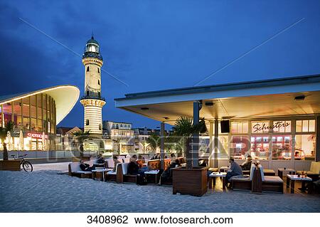 Teepott, lighthouse and beach bar in Warnemuende, Rostock, Germany View Large Photo Image Stock Image - Teepott, lighthouse and beach bar in Warnemuende, Rostock, Germany . Fotosearch
