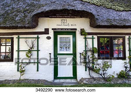 Stock Image - Thatched-roof house in Wyk, Foehr, Schleswig-Holstein, Germany . Fotosearch
