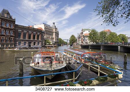 Tourist boat on the Amstel River, Amsterdam, Netherlands, elevated view View Large Photo Image Stock Photo - Tourist boat on the Amstel River, Amsterdam, Netherlands, elevated view . Fotosearch