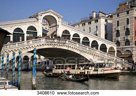 Stock Image - Tourist boats and gondolas under the Rialto Bridge on the Canale Grande, Venice, Italy . Fotosearch