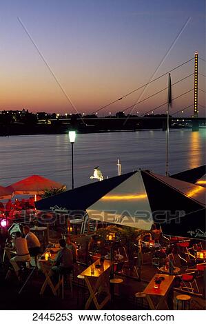 Tourists at restaurant on riverside during dusk View Large Photo Image Stock Image - Tourists at restaurant on riverside during dusk . Fotosearch