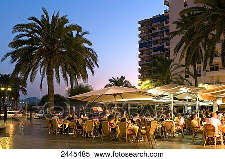 Tourists at sidewalk cafe at dusk, Ibiza, Balearic Islands, Spain View Large Photo Image Stock Photography - Tourists at sidewalk cafe at dusk, Ibiza, Balearic Islands, Spain . Fotosearch