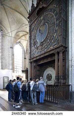 Stock Image - Tourists looking at big antique clock, Rostock, Mecklenburg-West Pomerania, Germany . Fotosearch