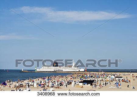 Stock Photo - Tourists on the beach of Warnemuende, ferry in the background, Rostock, Germany, elevated view . Fotosearch