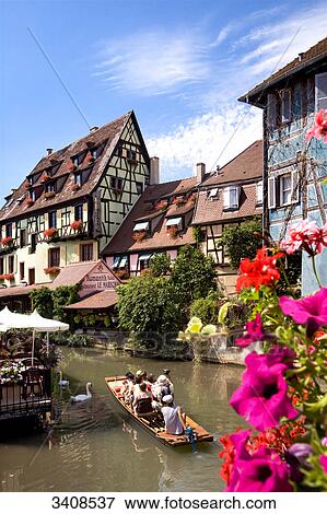 Stock Photo - Tourists sitting in a boat on a canal, Colmar, France, elevated view . Fotosearch